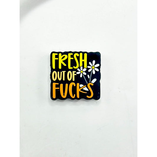 Black square patch with yellow text 'Fresh Out of Fucks' and white flowers on a white background

