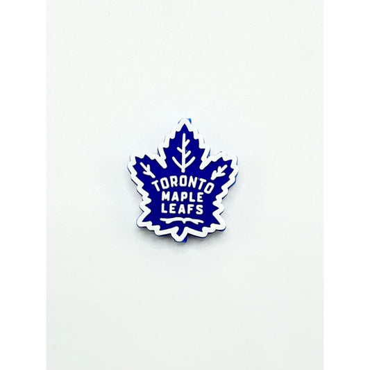 A silicone bead in the shape of a maple leaf with 'Toronto Maple Leafs' text in blue on a white background.

