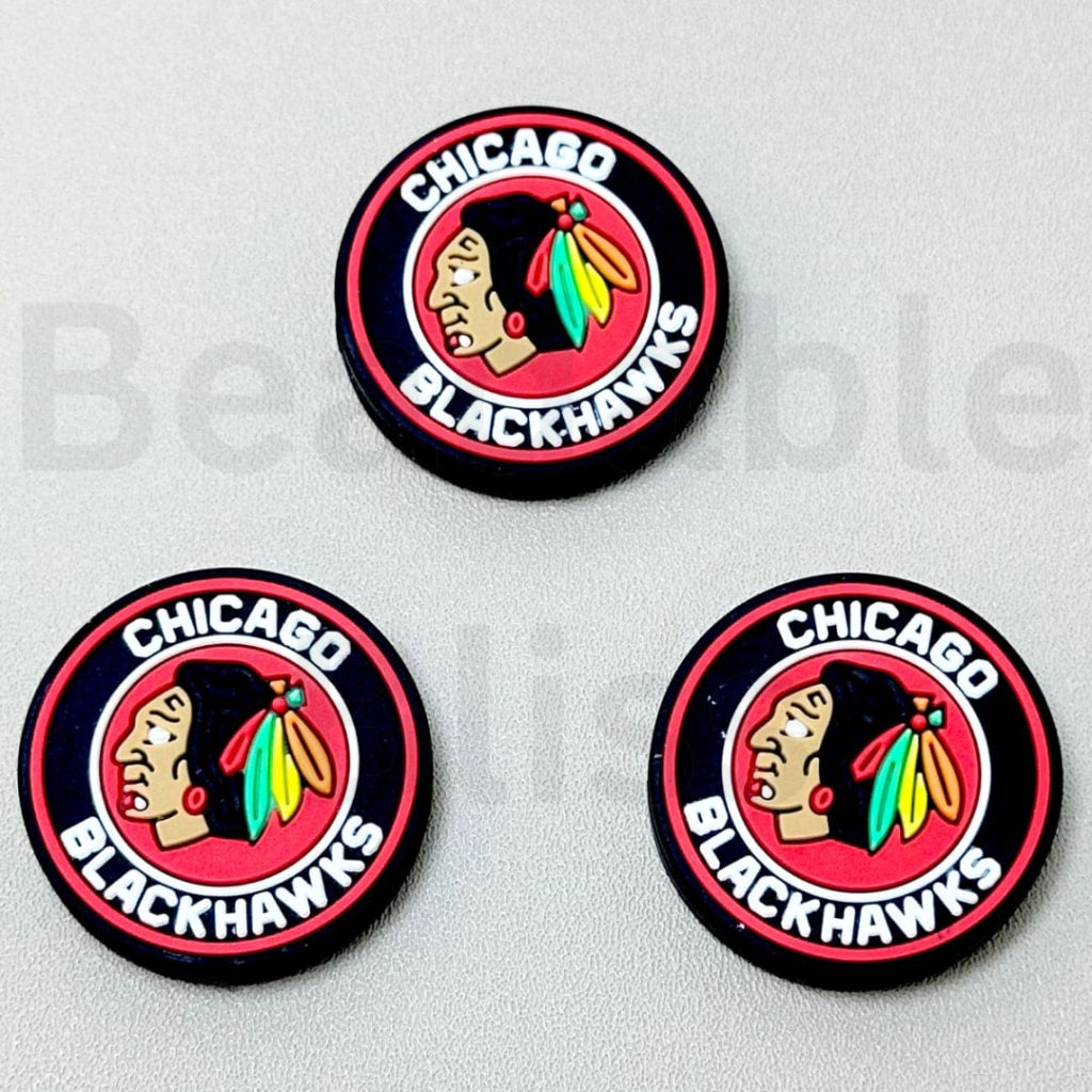 Three Chicago Blackhawks logo pins on a gray background

