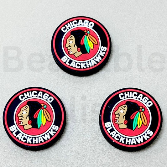 Three Chicago Blackhawks logo pins on a gray background

