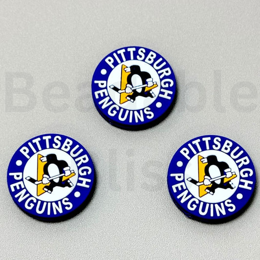 Three Pittsburgh Penguins buttons on a gray background

