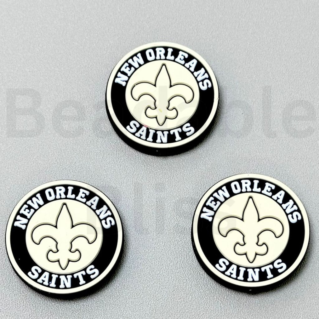Three New Orleans Saints logos on a gray background

