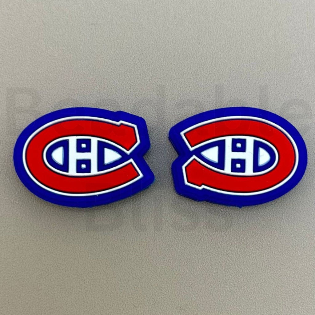 Two Montreal Canadiens logo earrings on a gray background

