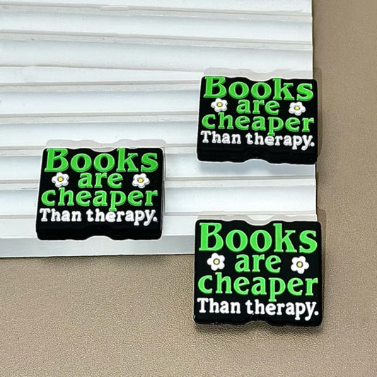 Rectangular silicone beads with the text 'Books are cheaper Than therapy' printed on them, displayed against a light background.

