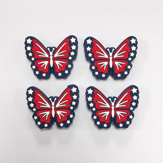 Four butterfly-shaped decorations with a red, white, and blue design on a light gray background.

