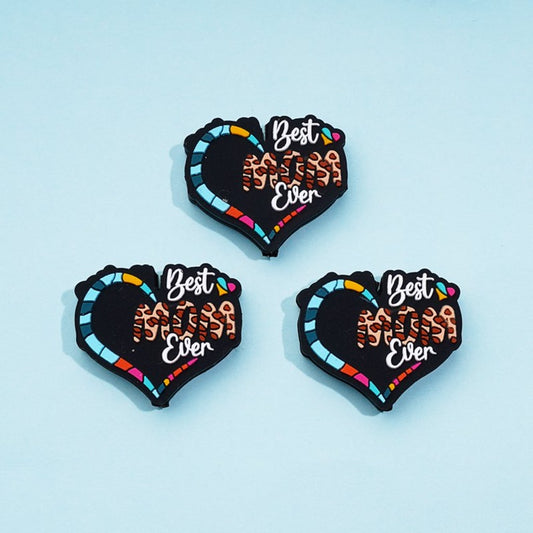 A set of three silicone beads in the shape of hearts with the phrase 'Best Mom Ever' printed on them, in multicolor design.

