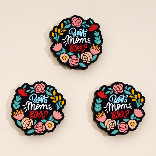 Three round silicone beads with a floral pattern and the text 'Best Mom Ever' printed on them.

