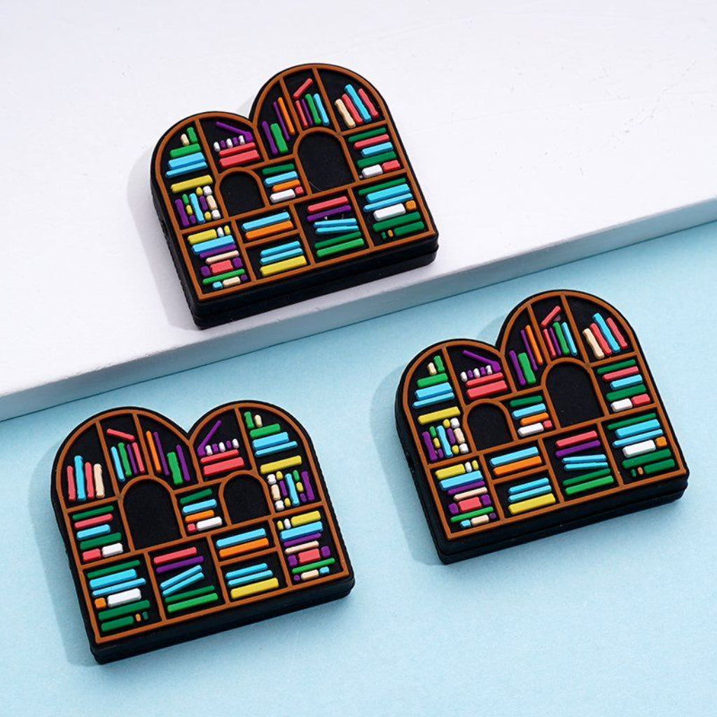 Silicone beads designed to look like miniature bookshelves with multicolored books.

