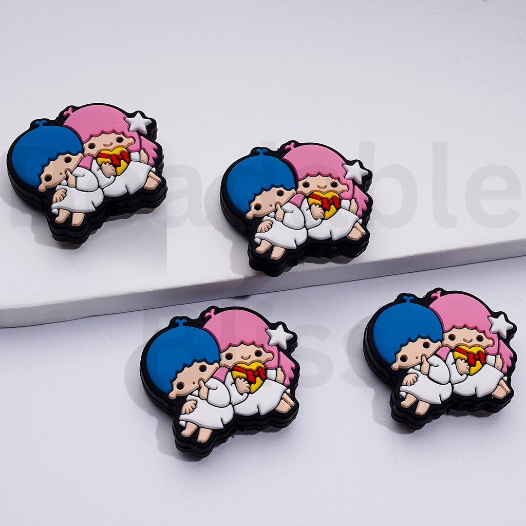 Four cartoon character pins with blue, pink, and white colors on a white background.

