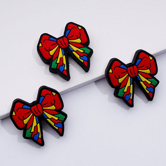 A set of silicone beads in the shape of colorful bowknots.

