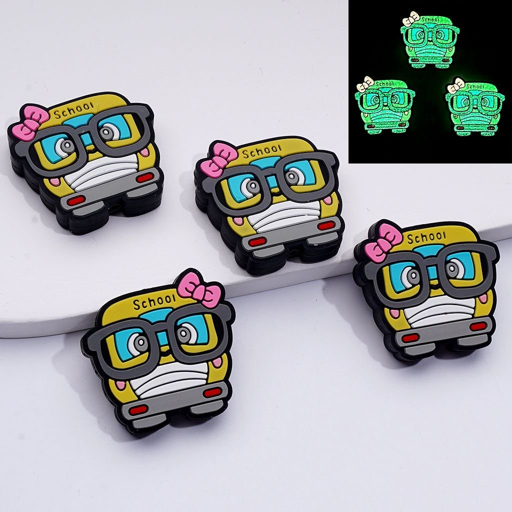 Glowing school bus-shaped pins with glasses and bows on a white background.

