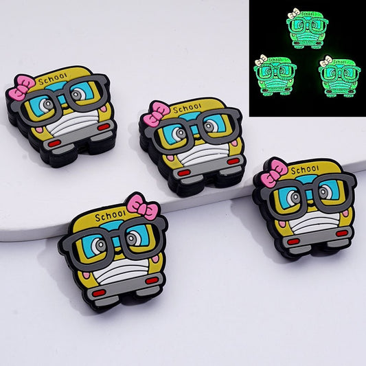 Glowing school bus-shaped pins with glasses and bows on a white background.

