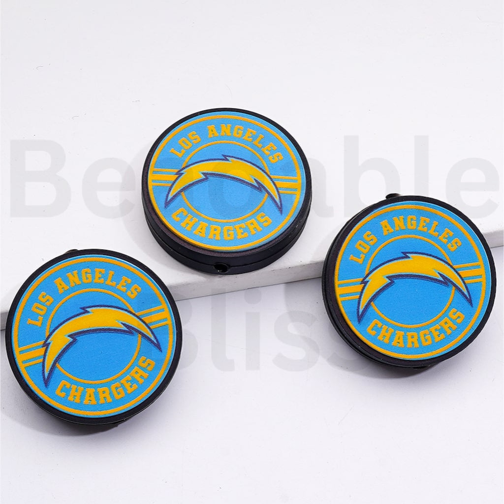 Three Los Angeles Chargers logo coasters on a white surface.


