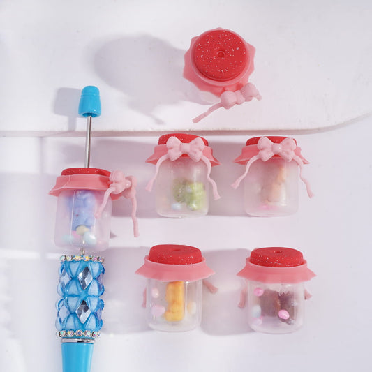 Set of decorative jars with lids and a blue straw on a white background