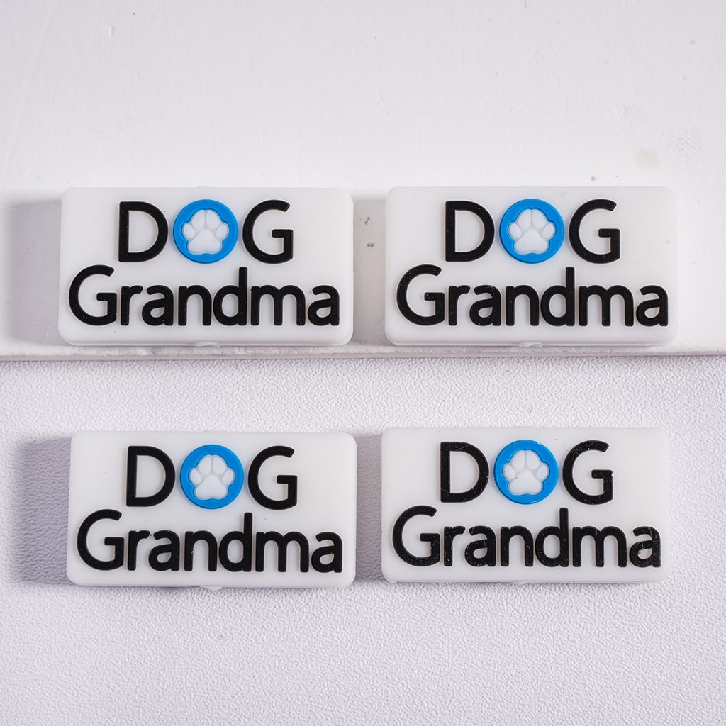 Four 'DOG Grandma' dog tags on a white background

