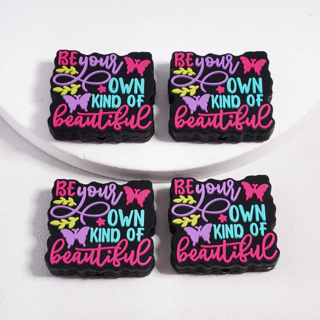 Four motivational coasters with 'Be your own kind of beautiful' text and butterfly graphics on a white surface.

