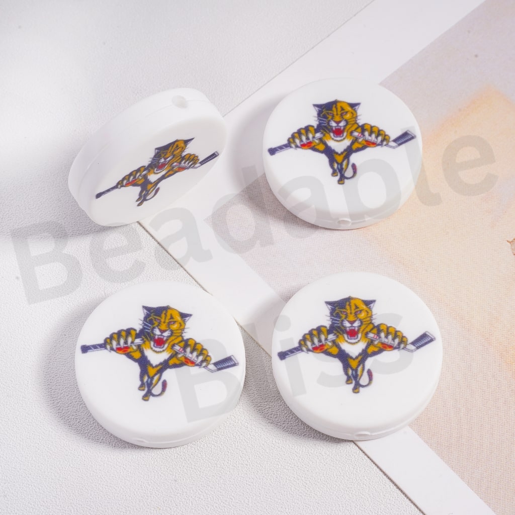 Four white round objects with a colorful panther design on a light background.

