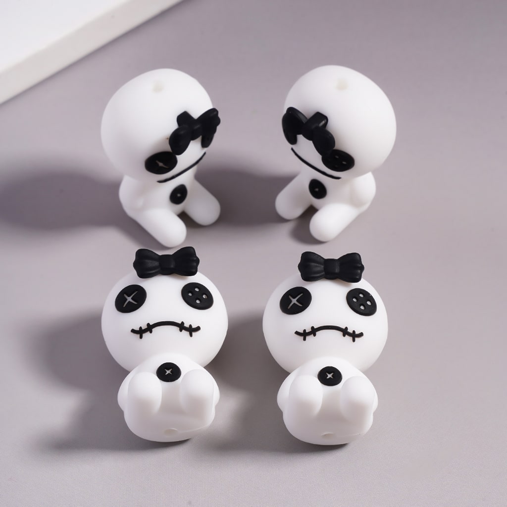 Set of white ghost figurines with black bow ties on a gray background

