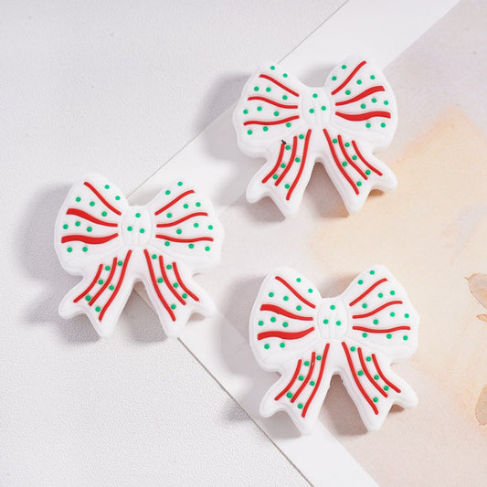 Three decorative candy cane-shaped cookies on a light surface.

