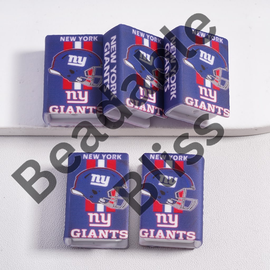 Five New York Giants-themed lighters on a white surface with a brand name visible.

