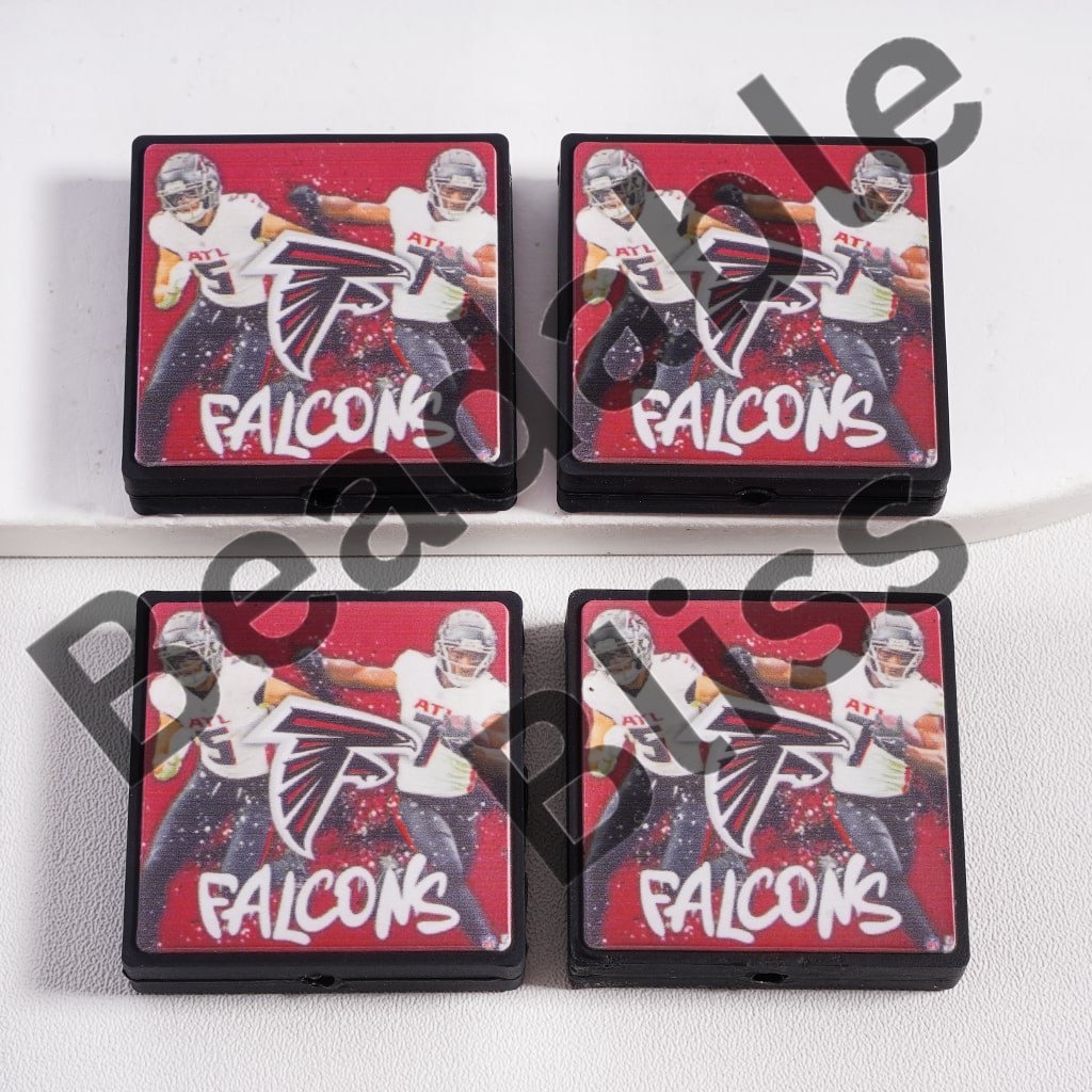 Four Atlanta Falcons-themed coasters on a white surface

