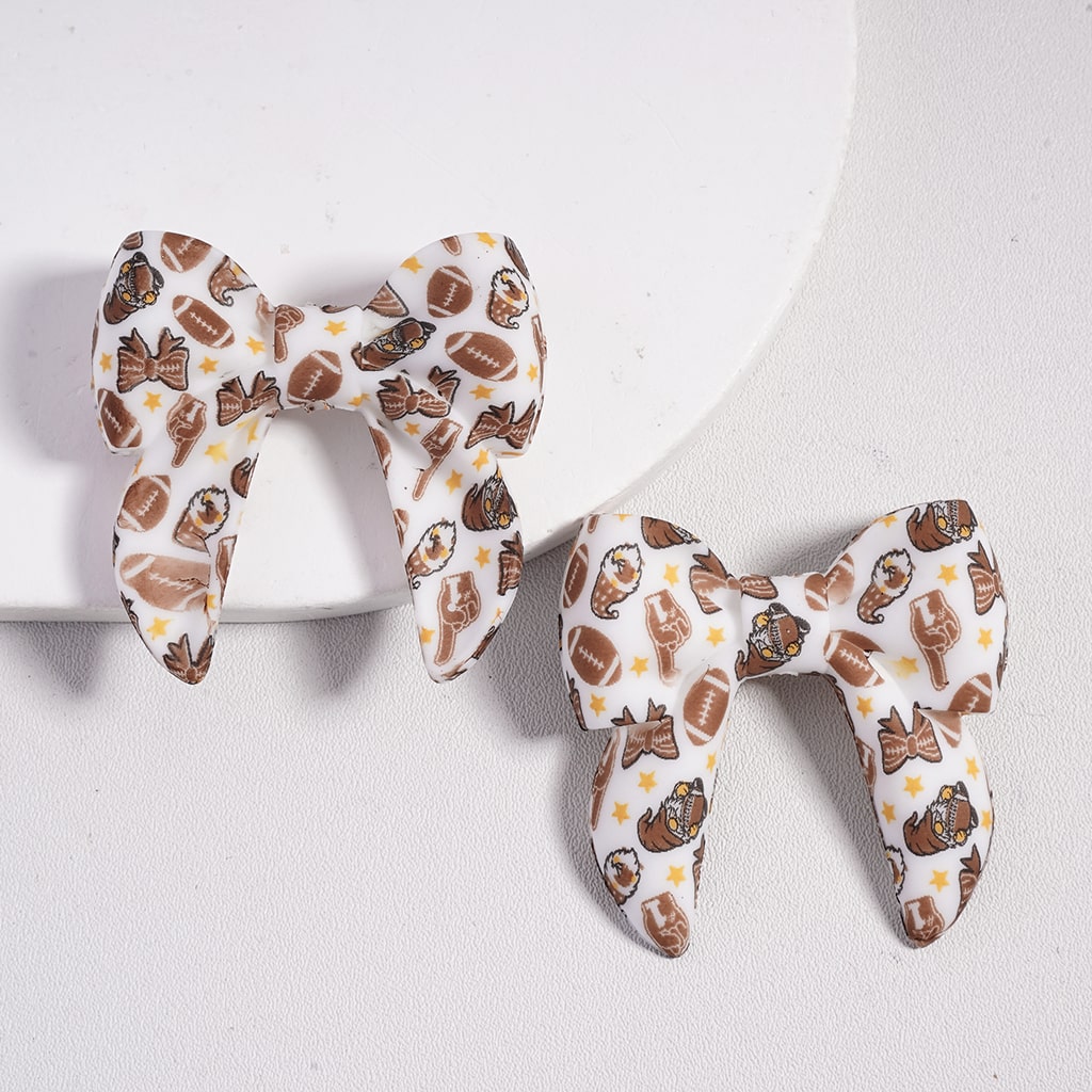 Pair of bow-shaped earrings with a pattern on a white background

