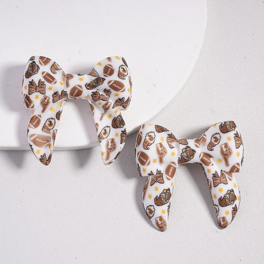 Pair of bow-shaped earrings with a pattern on a white background

