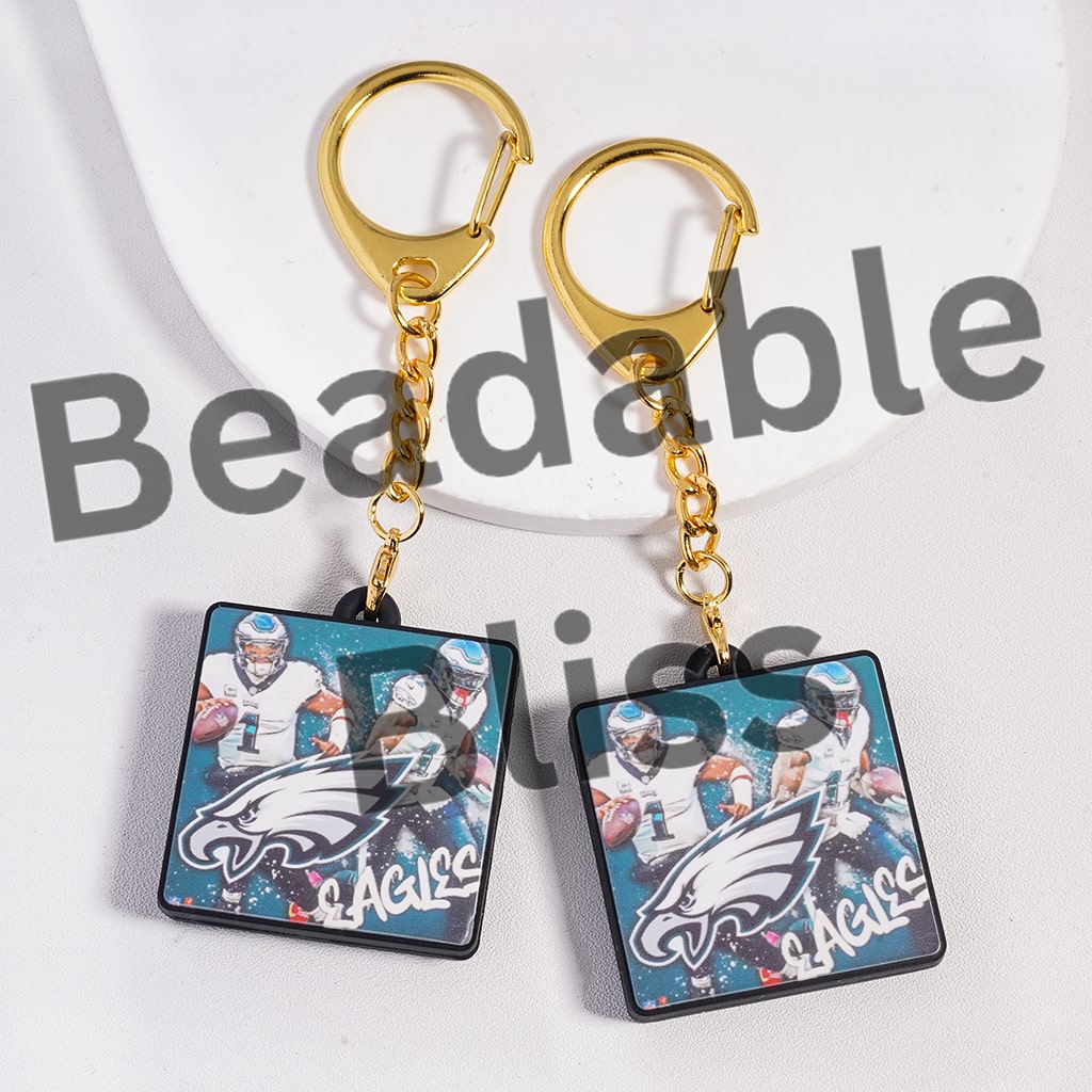 Pair of keychains with Eagles logo and players on a white background