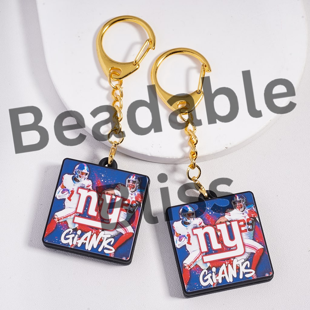 New York Giants keychains with gold chains on a white background