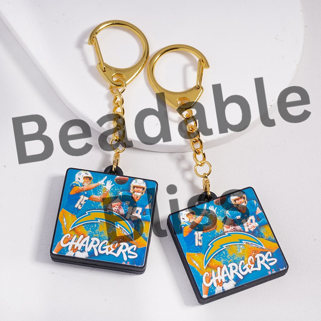 Two Chargers keychains with gold hooks on a white background
