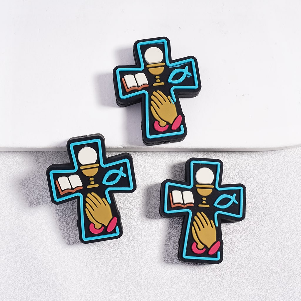 Three cross-shaped earrings with religious symbols on a white background
