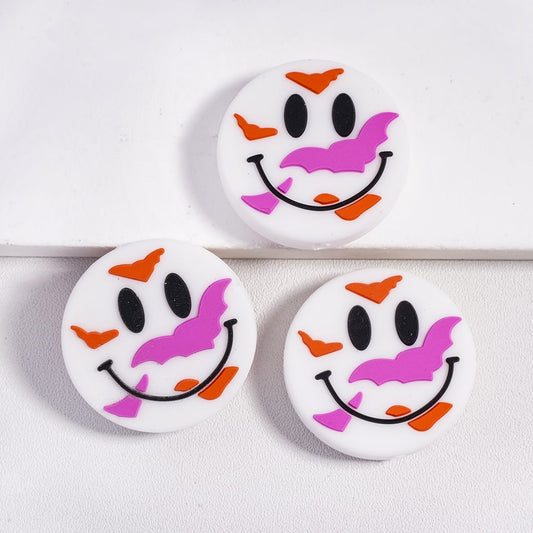 Three round buttons with ghost face designs on a white background