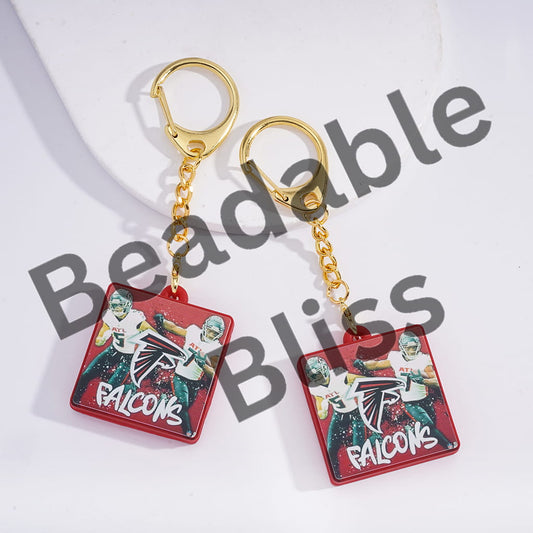 Two keychains with a sports team logo on a white background, branded 'handsonsupply.com'.