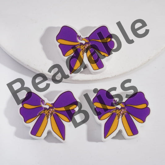 Purple and yellow bow-shaped earrings on a white background with 'handsonsupply.com' branding.