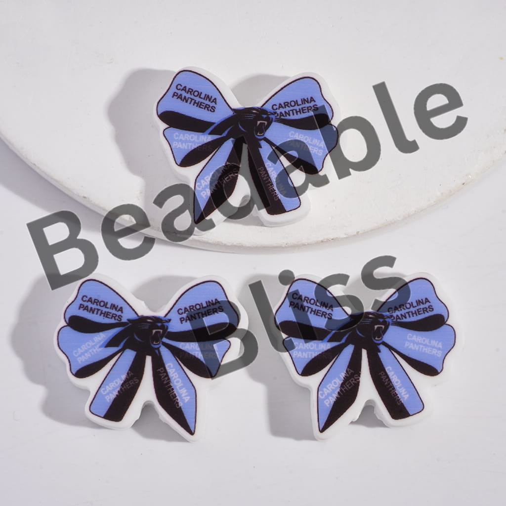 Carolina Panthers-themed bow-shaped earrings on a white background with 'handsoffisupply.' branding.