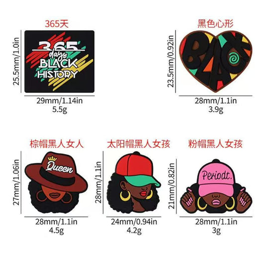 A selection of silicone beads with various designs including representations of Black History Month and Juneteenth themes. Each bead is colorful and has a unique design.

