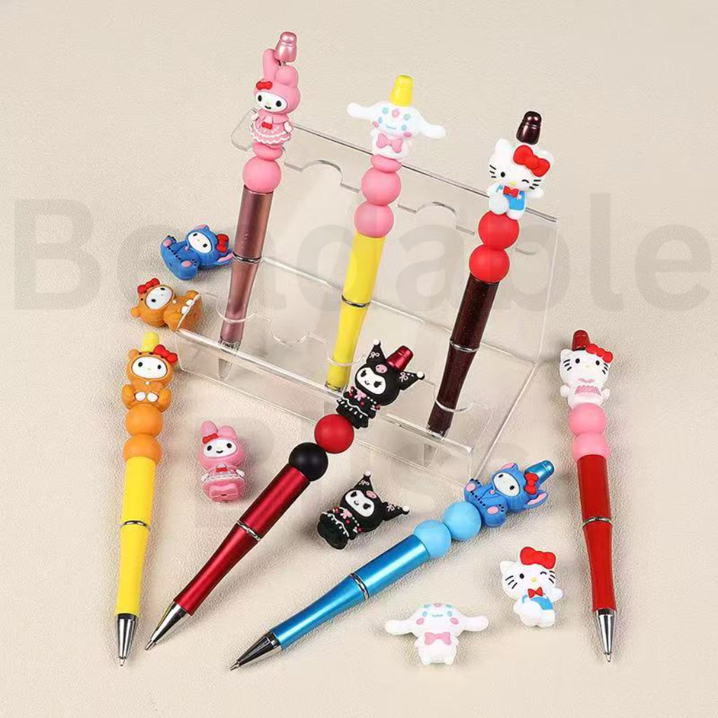 Set of colorful pens with cartoon character ends on a beige background, branded 'beadablebliss'.


