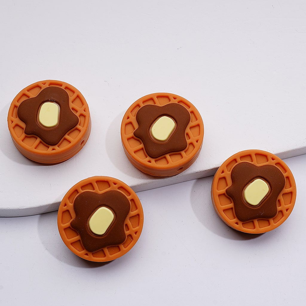 Four waffle-shaped earrings with a brown center on a white background

