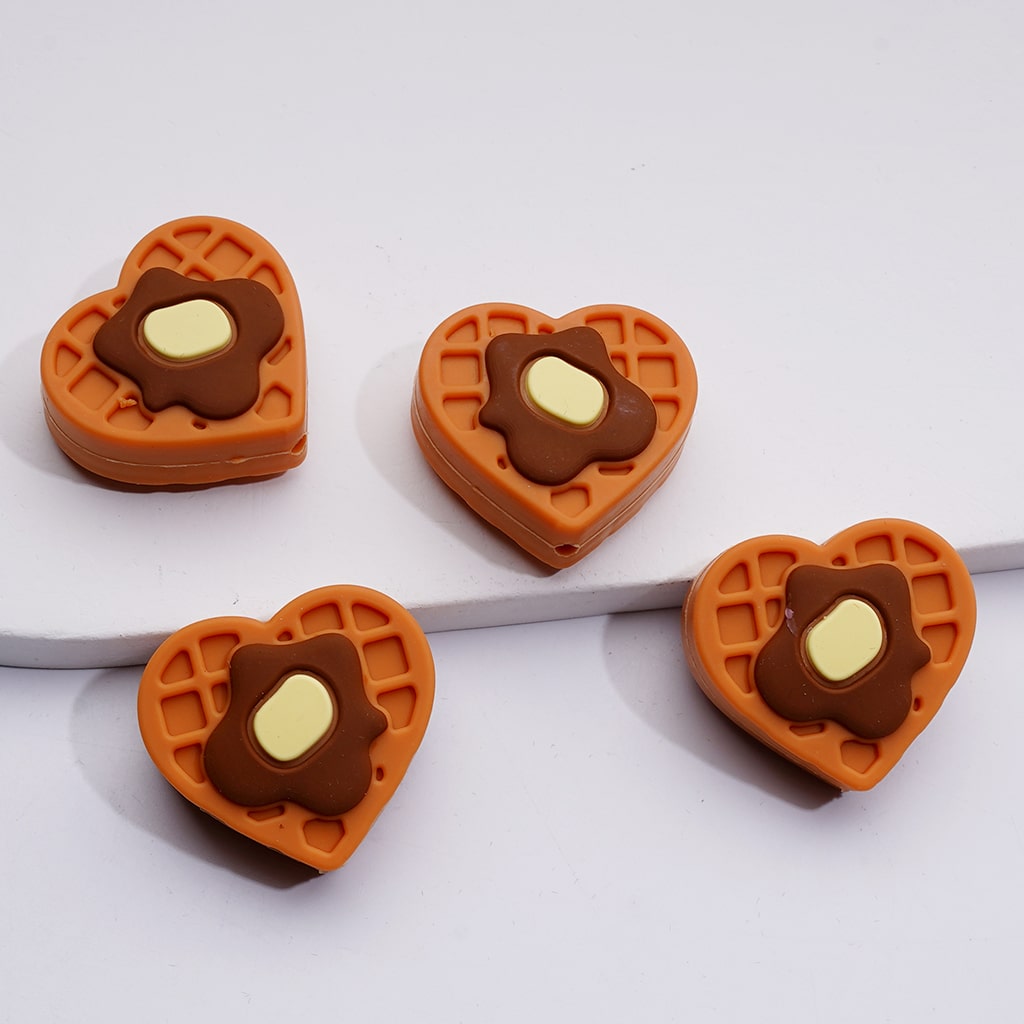 Heart-shaped waffle cookies with chocolate and cream filling on a white background

