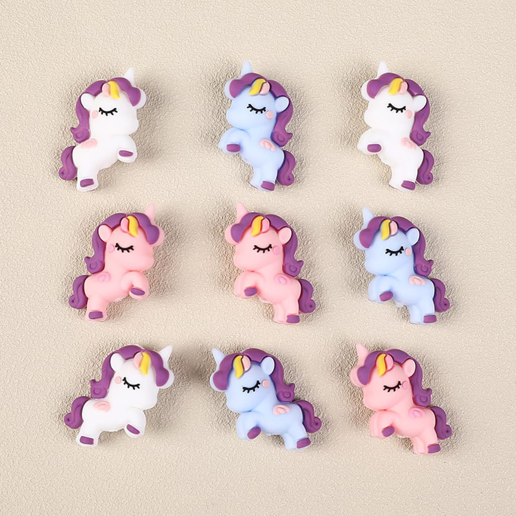 Set of small unicorn figurines in various colors on a beige background

