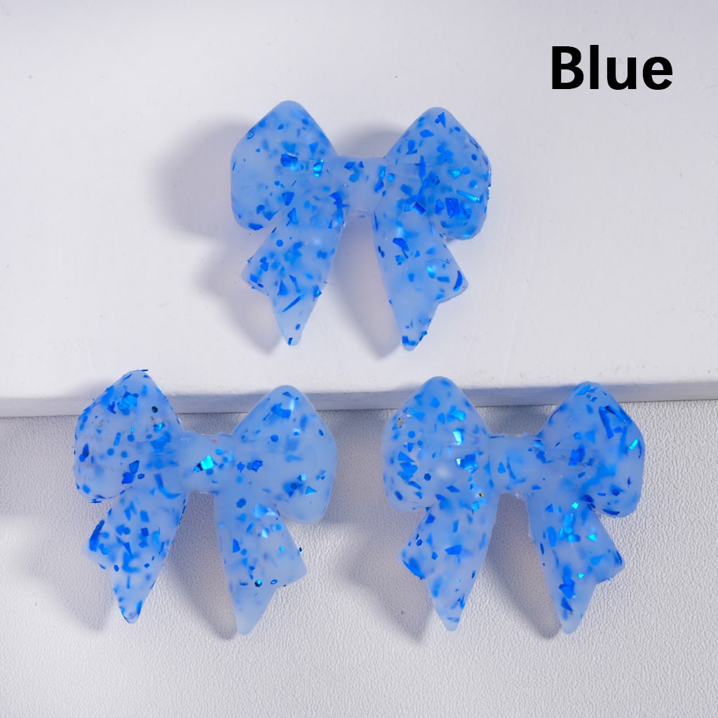 Blue glittery bow-shaped objects on a white background with 'Blue' text.

