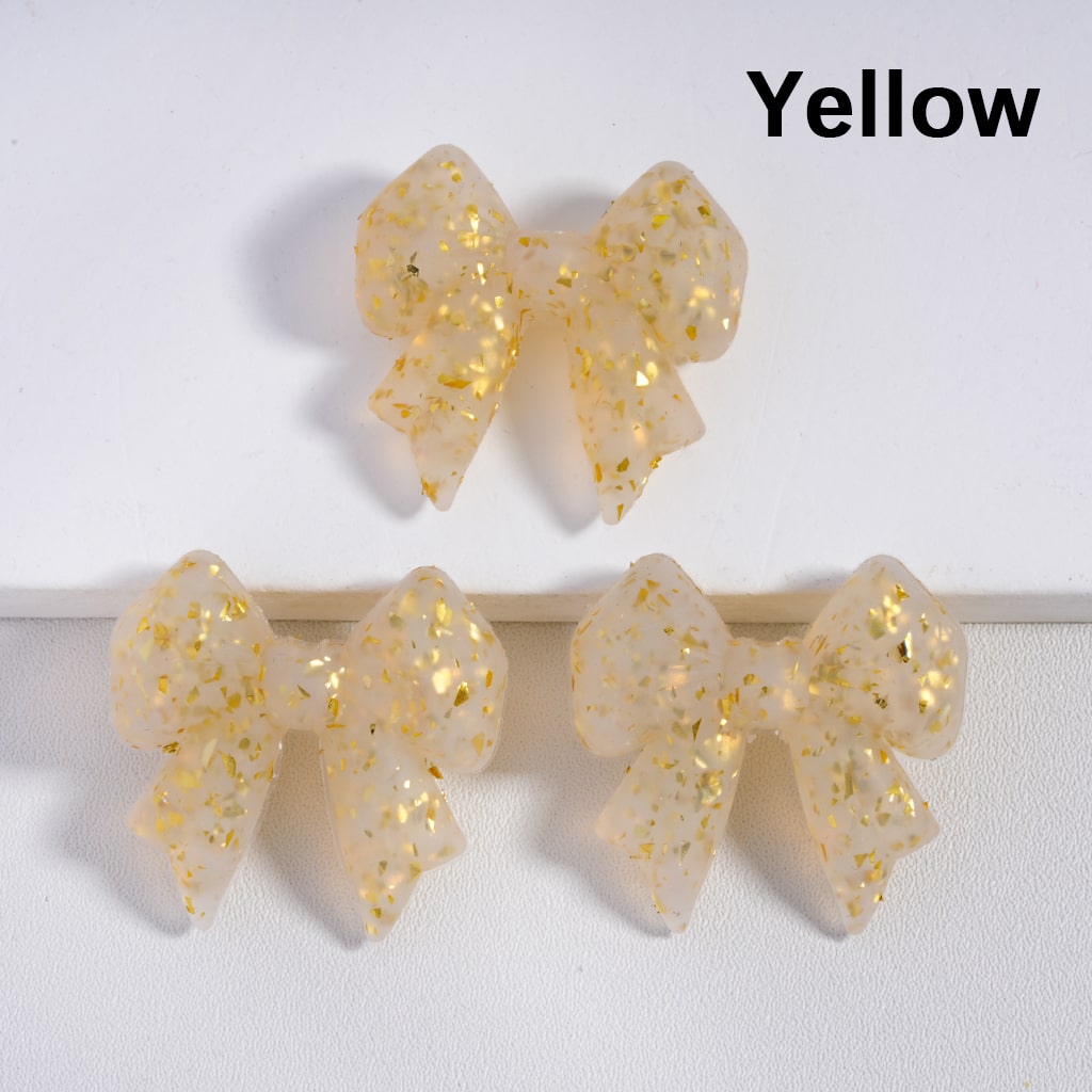 Yellow bow-shaped earrings on a white background with 'Yellow' text above.

