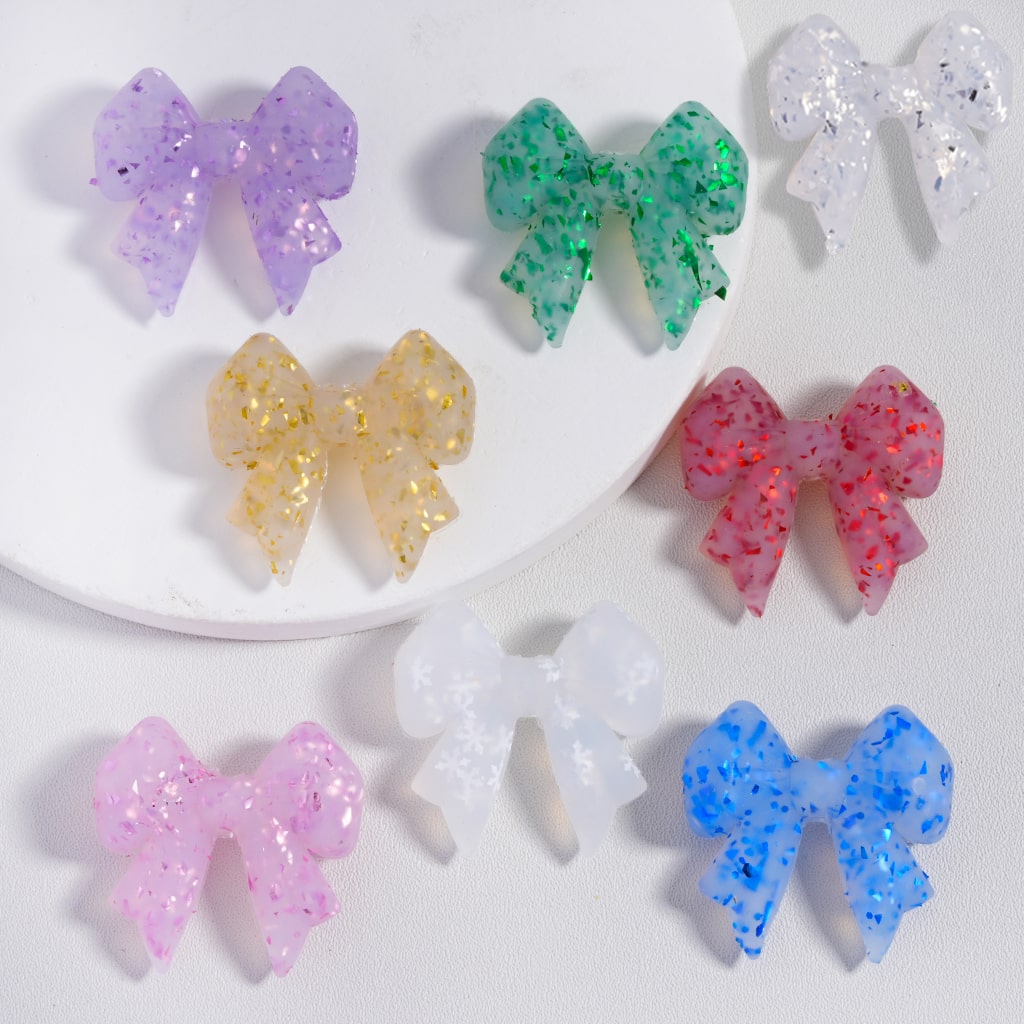 Colorful glittery bow-shaped objects on a white background

