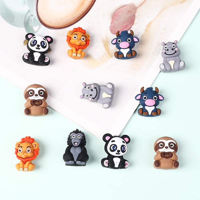 Set of colorful animal-shaped refrigerator magnets on a white surface.

