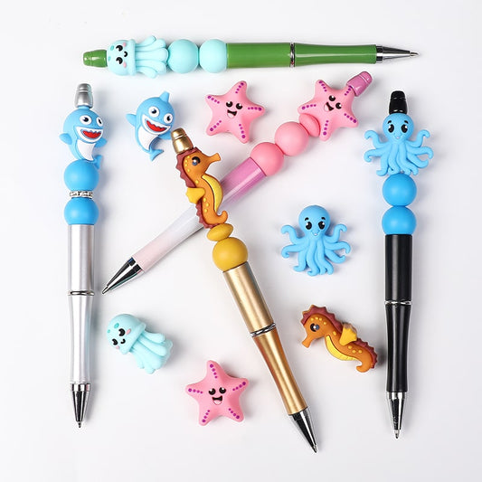 Set of pens with colorful ocean-themed pen tops on a white background

