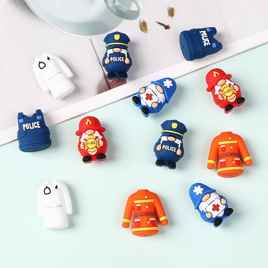 Colorful toy figures of police, fireman, and ambulance on a light surface.

