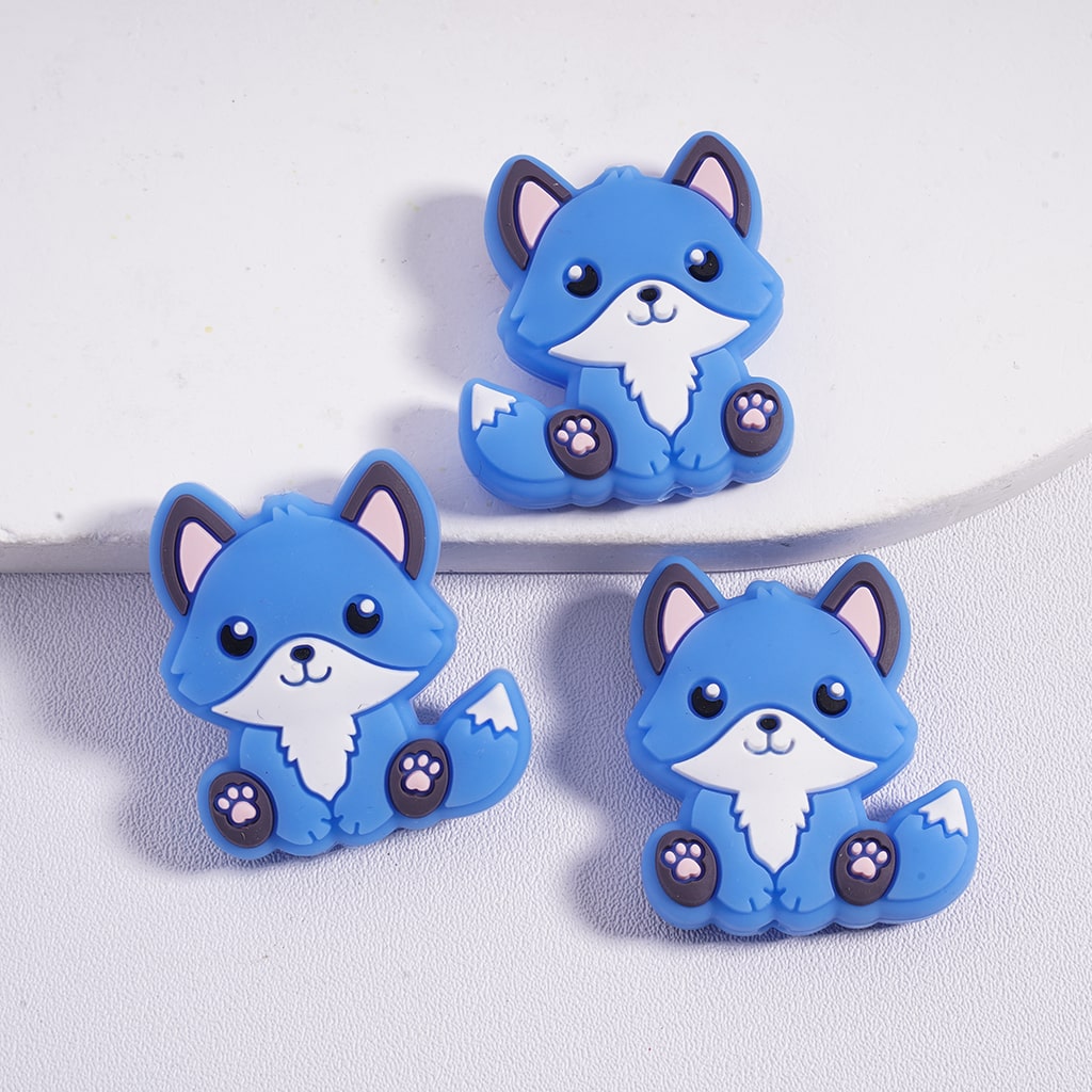 Three blue cartoon fox figurines on a light gray background