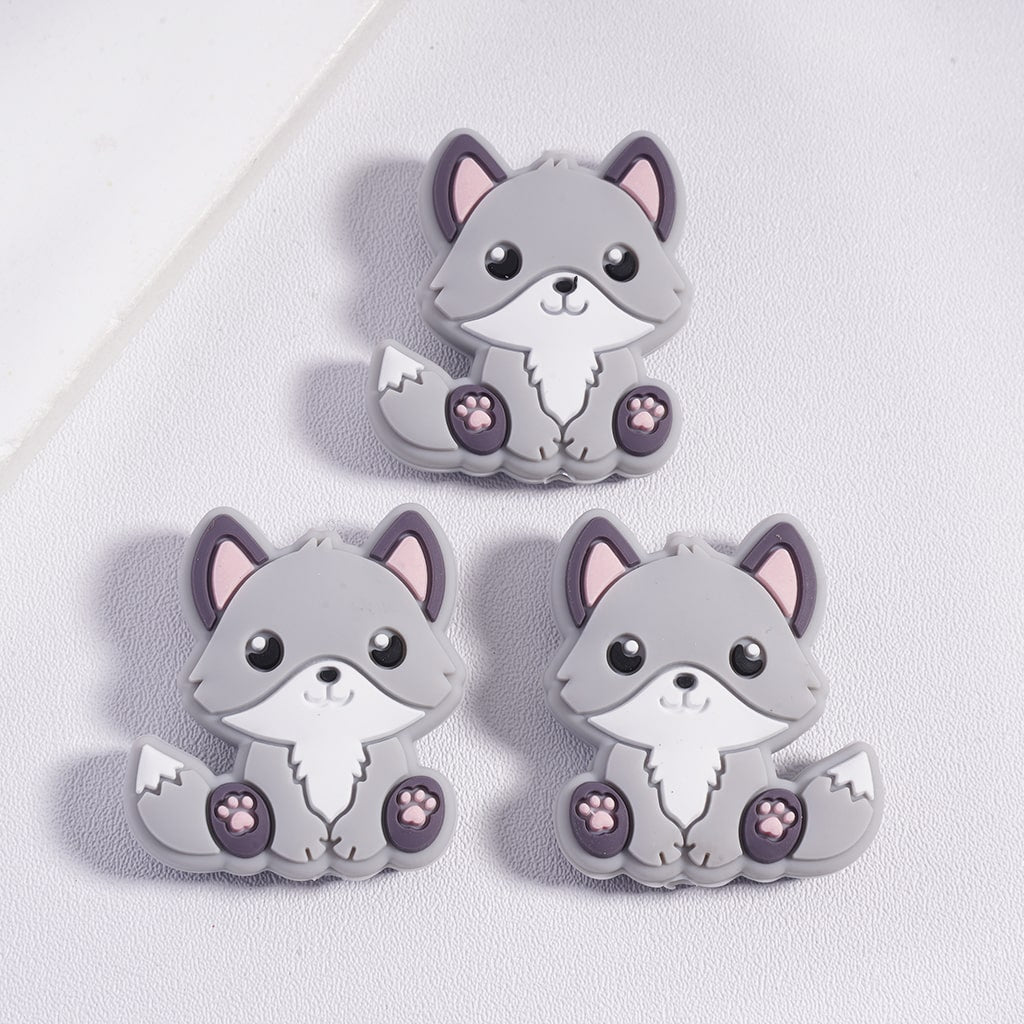 Three gray cartoon fox figurines with pink accents on a light gray background