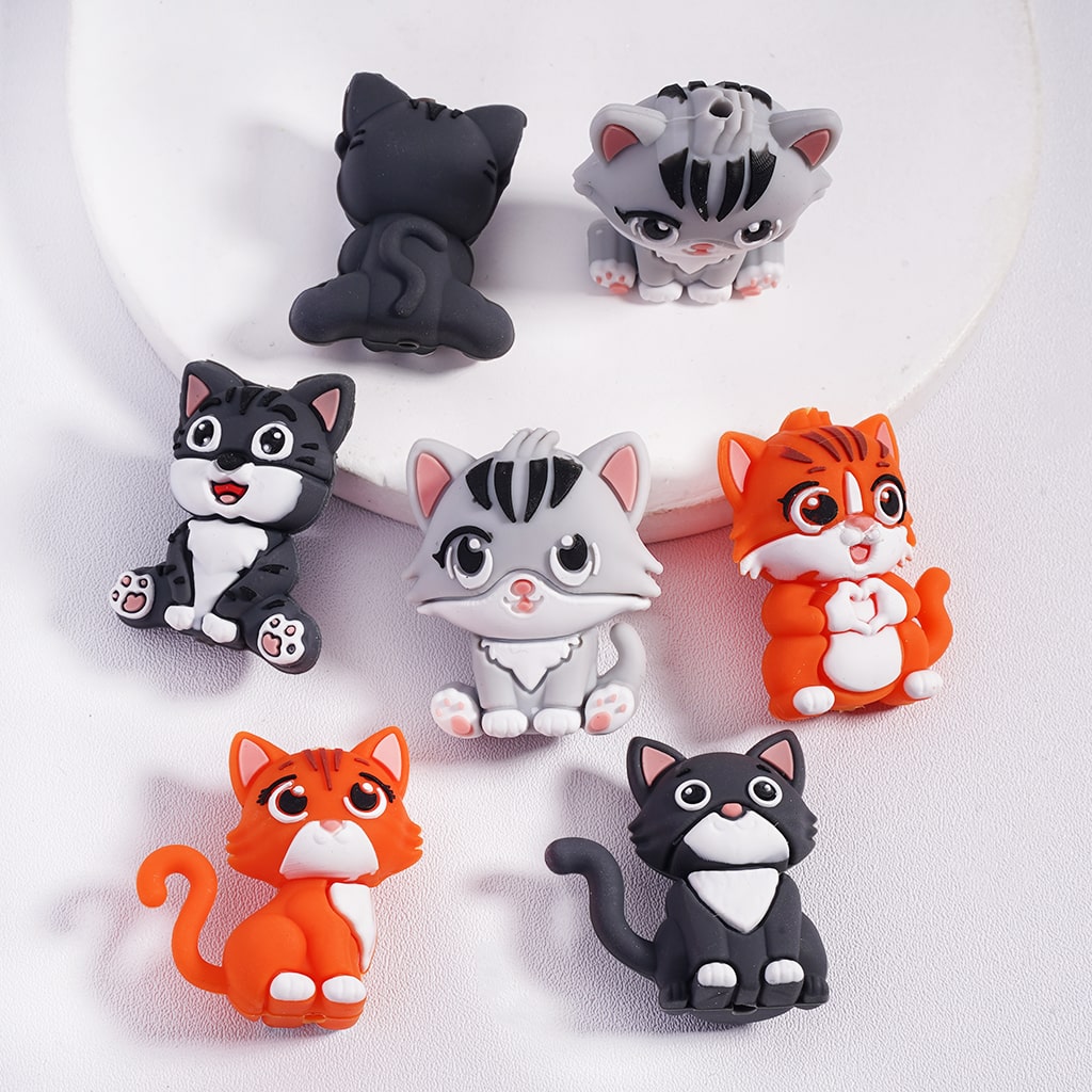 Set of colorful cat-shaped figurines on a white background