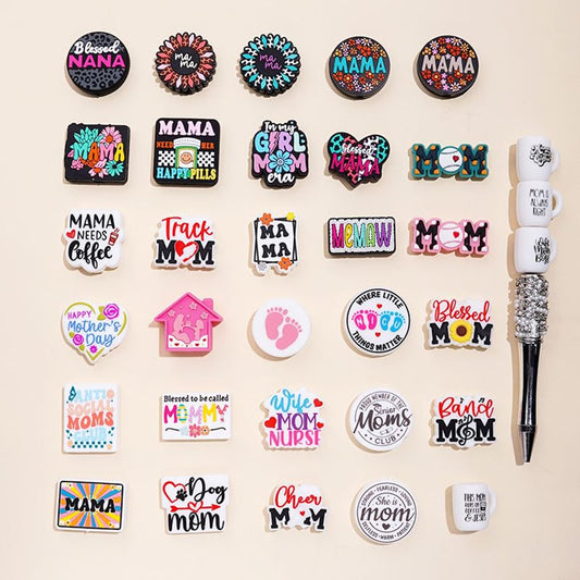 An assortment of silicone beads with various designs related to mothers and motherhood, displayed on a neutral background.

